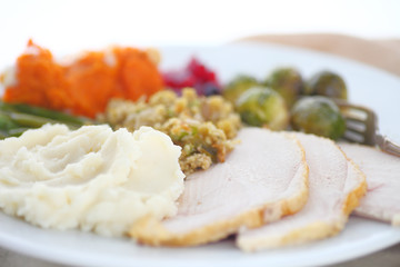 Turkey with stuffing, mashed potatoes, brussels sprouts, sweet potatoes and cranberry sauce