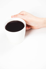 girl holding a cup of black coffee in hand.