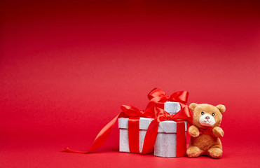 Christmas gifts on red background with toy and ribbon