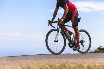 Naklejka premium Man on a bicycle on a road between the beautiful mountains
