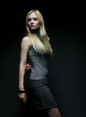 Fototapeta na wymiar Portrait of beautiful young blonde girl in black dress. 