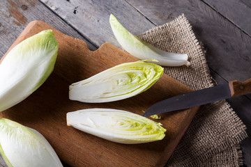 Top view on endive lying on wooden background. - obrazy, fototapety, plakaty