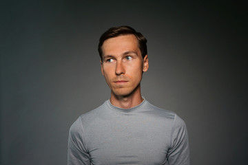 Young man in t-shirt on gray background.