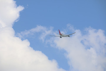 behind of commercial plane into blue sky
