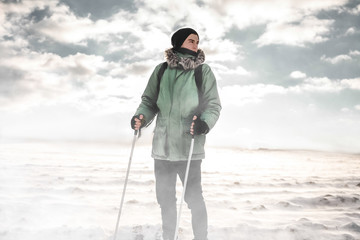 The man in the green jacket on skis in snow storm