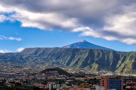 Scenic view of monumental volcano Mount Teide with Puerto Cruz city in a front, Tenerife, Canary Islands, Spain.