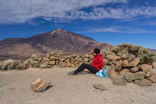 Young female hiker is enjoying view of Mount Teide volcano. Tenerife, Canary Islands, Spain.