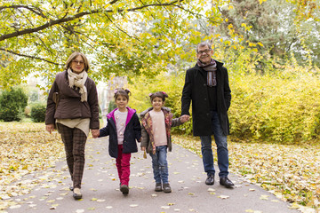 Grandparents with grandchildren in autumn park