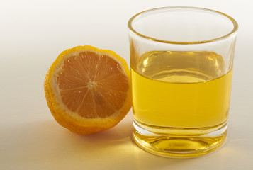 lemon and a glass of lemonade on a white background
