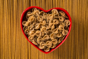 Wholemeal Pasta. Integral tie or farfalle into a heart bowl over