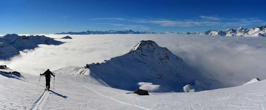 Scialpinista con mare di nuvole sullo sfondo