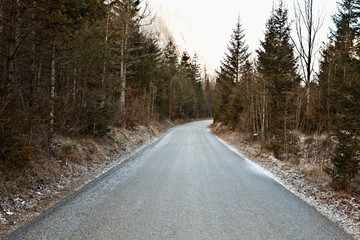 Fototapeta premium Straße durch den Wald bei winterlichen Fahrverhältnissen