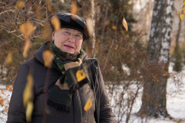 Portrait of old woman posing in winter park, close up