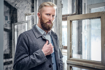 Bearded male dressed in an classic jacket posing on old, vintage