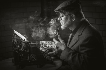 Älterer Schriftsteller mit Pfeife und alter Schreibmaschine