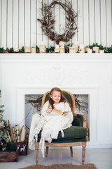 Portrait of 7 years old child reading book at home on christmas