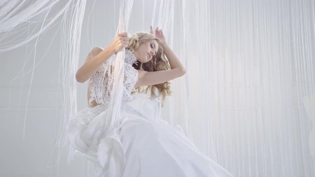 Pretty, young blond woman in a bright, luxurious room