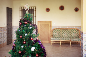 Fototapeta na wymiar A pretty artificial Christmas tree with some Christmas decoratio