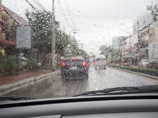 Road view through car windshield with rain drops, Driving in rain.