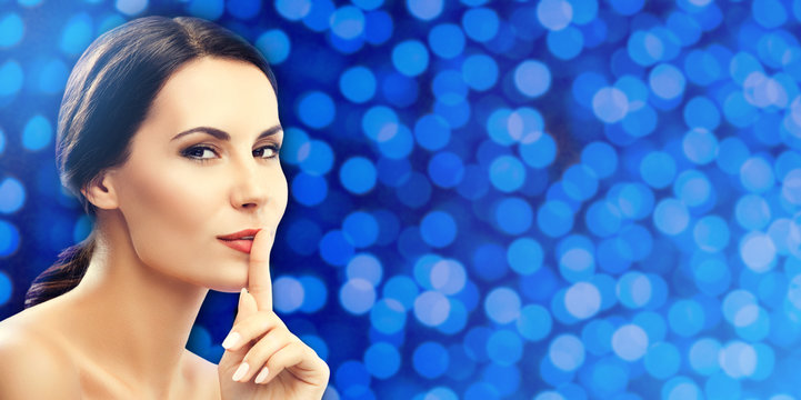 Woman keeping finger on her lips, on blue lights