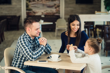 Family Enjoying tea In Cafe Together