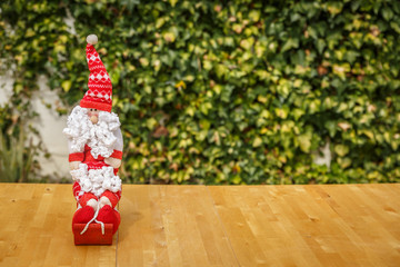 Cute Santa Claus on a wooden table with a green background