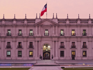 Naklejka premium Chile, Santiago, Twilight view of La Moneda Palace from the Plaza de la Ciudadania.