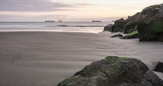 Panning time lapse near the jetty at Seal Beach, California. With dramatic clouds, fast moving waves, and off shore container ships