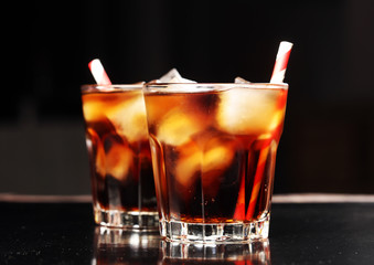 Large glasses of cola soda drinks with straws