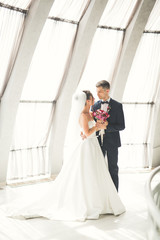 Fototapeta premium Beautiful couple, bride and groom posing on balcony with backgrounf of old city