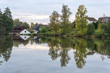 Fototapeta premium Mirror image of a green town in water