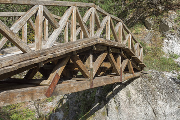 Old wooden footbridge with rails over river. Prionia, Mount Olympus, Pieria, Greece.