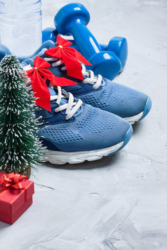 Christmas sport composition with sport shoes, dumbbells, gift