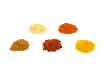 Heaps of several seasoning spices on white