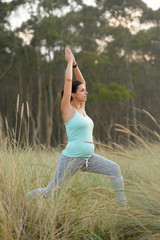 Pregnant fitness woman doing yoga breathing exercise outdoor