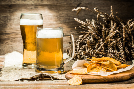 Mug, glass of beer on cloth with spikelets and chips