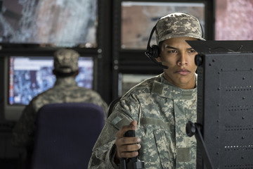 Military drone operator looking at computer screen