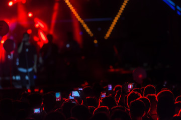 Fototapeta na wymiar Hand with a smartphone records live music festiva
