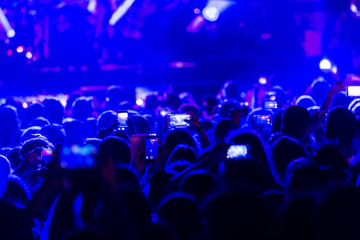 Obraz premium Hand with a smartphone records live music festiva
