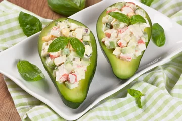 Photo sur Plexiglas Plats de repas Avocado salad / Avocado stuffed with crab, cucumber, egg, red onion and sauce mayonnaise on white plate