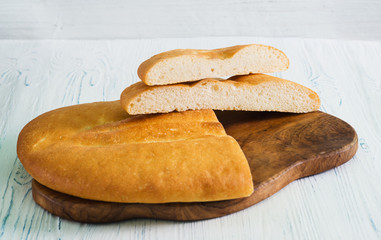 Sliced wheat pita bread on a light wood table