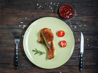 grilled beef steak and tomatoes, garlic sauce on dark plate