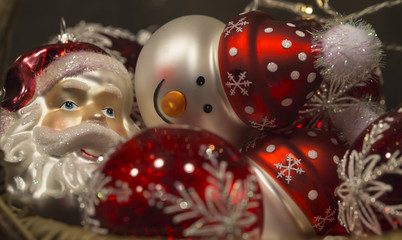 Schöne rote und weisse Christbaumkugeln in Form eines Weihnachtsmannes und eines Schneemannes mit roten Mützen