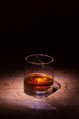 Glass of whiskey on wooden table
