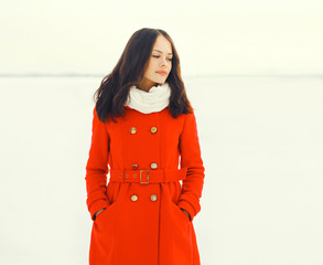 Fashion beautiful young woman wearing a red jacket in winter fie
