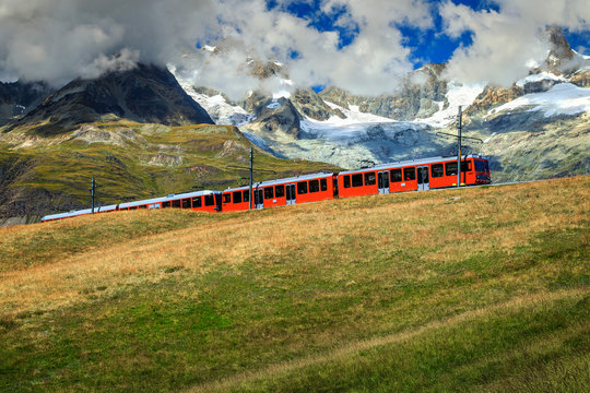 Electric tourist train with high mountains,Switzerland,Europe