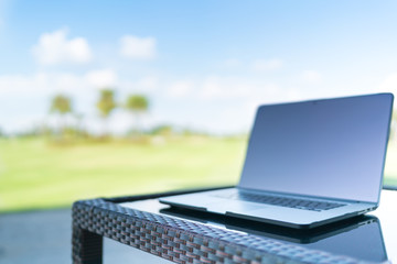 Laptop on golf course blur background with copy space, business or work from anywhere concept,...