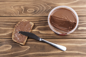 Bread with chocolate cream on wooden table