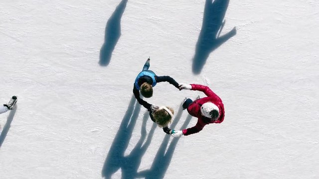 Aerial view of ice skating family outdoor, ice rink Medeo