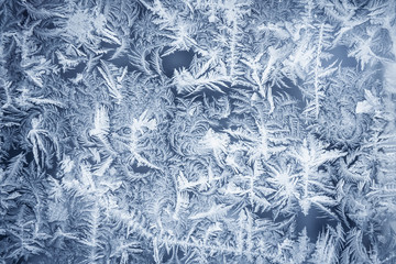 Ornate frost pattern on frosted window as Christmas background 
